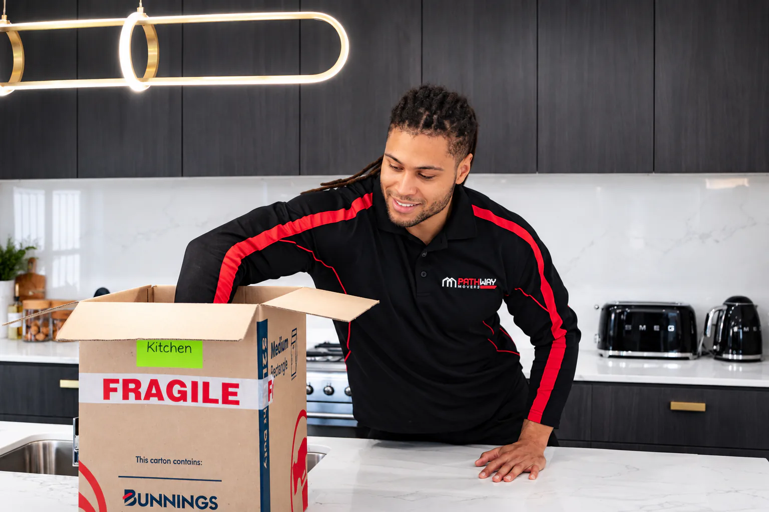 Pathway mover packing kitchen items into a moving box